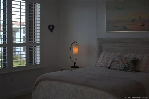 a bed sitting in a bedroom next to a window
