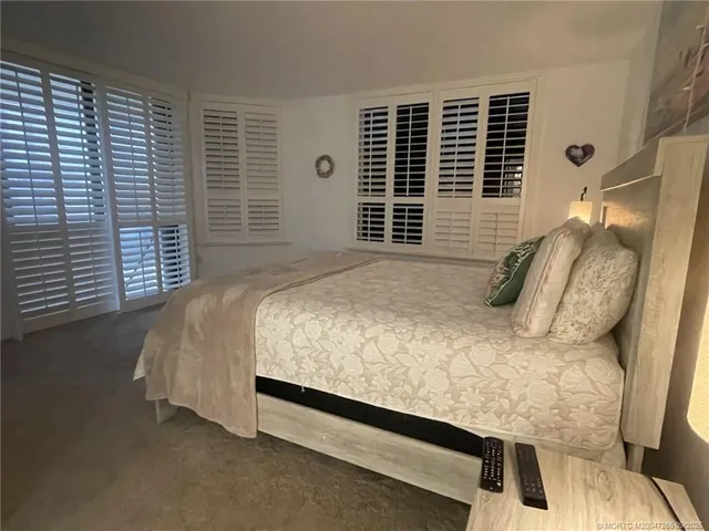 a bed sitting in a bedroom next to a window and wooden floor