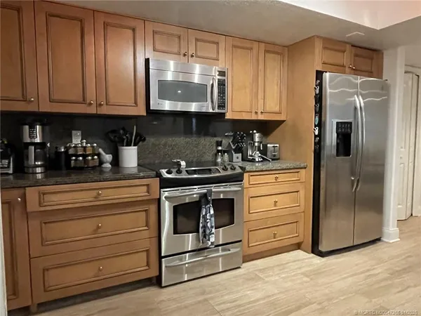a kitchen with stainless steel appliances granite countertop cabinets and a refrigerator