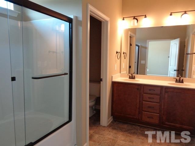 111 Torpoint Road Durham, NC 27703 - Photo 17 of 25 a bathroom with a double vanity sink and a mirror