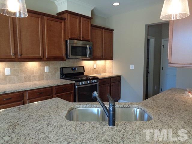 111 Torpoint Road Durham, NC 27703 - Photo 4 of 25 a kitchen with stainless steel appliances granite countertop a sink stove and microwave