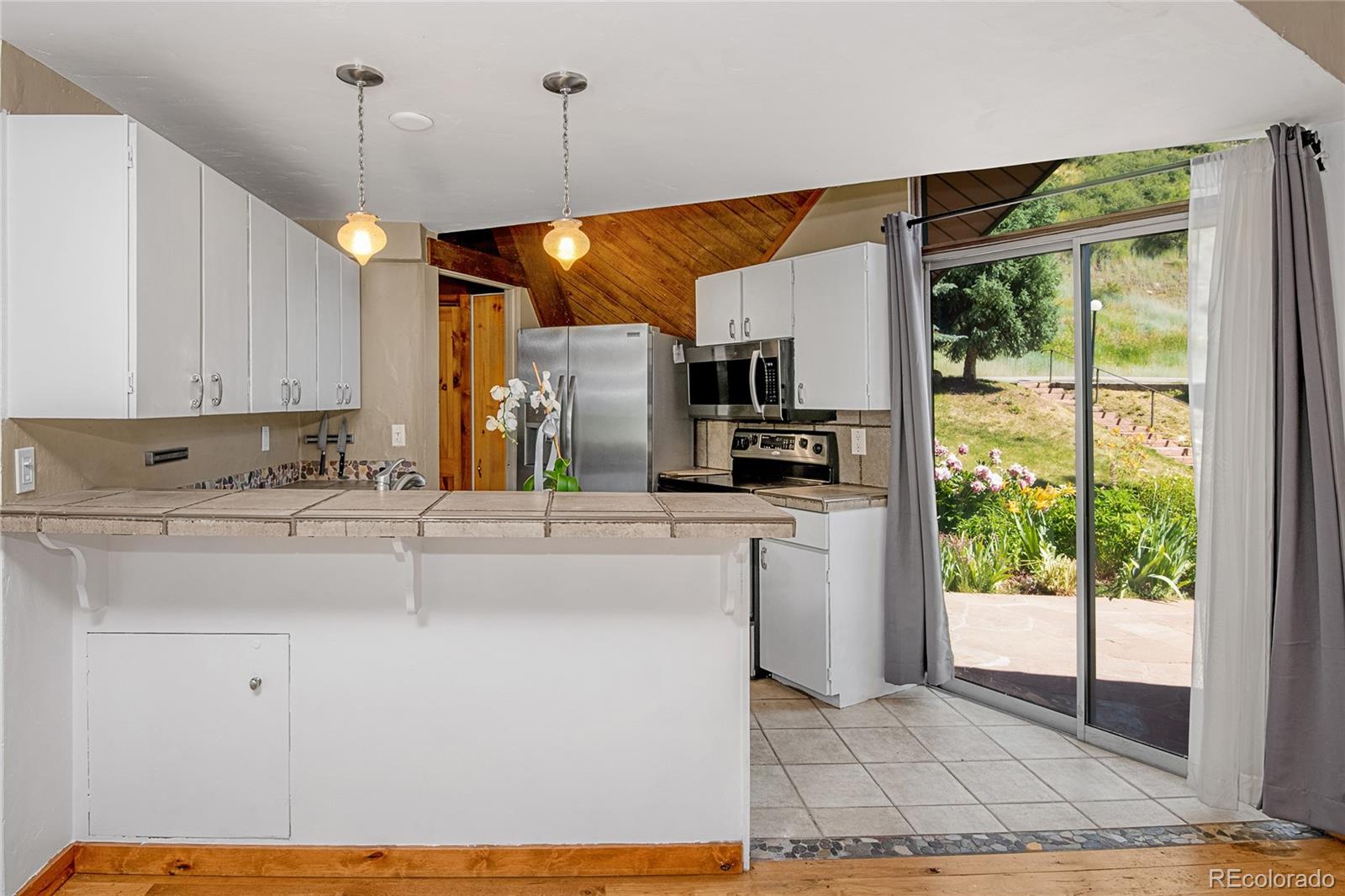 1400 Lions Ridge Loop, Unit A5 Vail, CO 81657 - Photo 11 of 28 a kitchen with kitchen island a counter top space a sink stainless steel appliances and cabinets