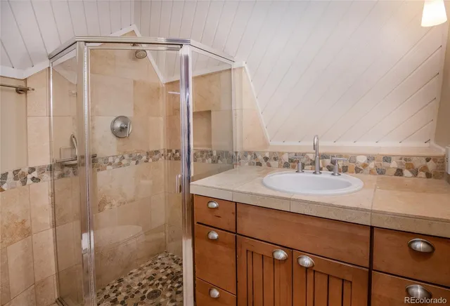 a bathroom with a granite countertop sink a shower and a mirror
