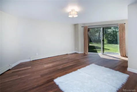 a view of a room with wooden floor and a window