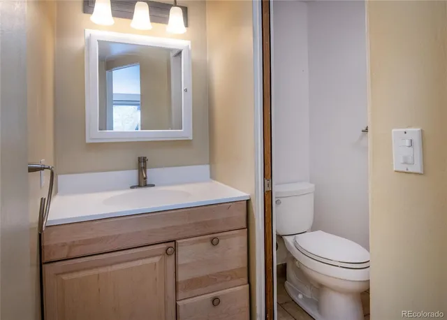 a bathroom with a toilet a sink and mirror