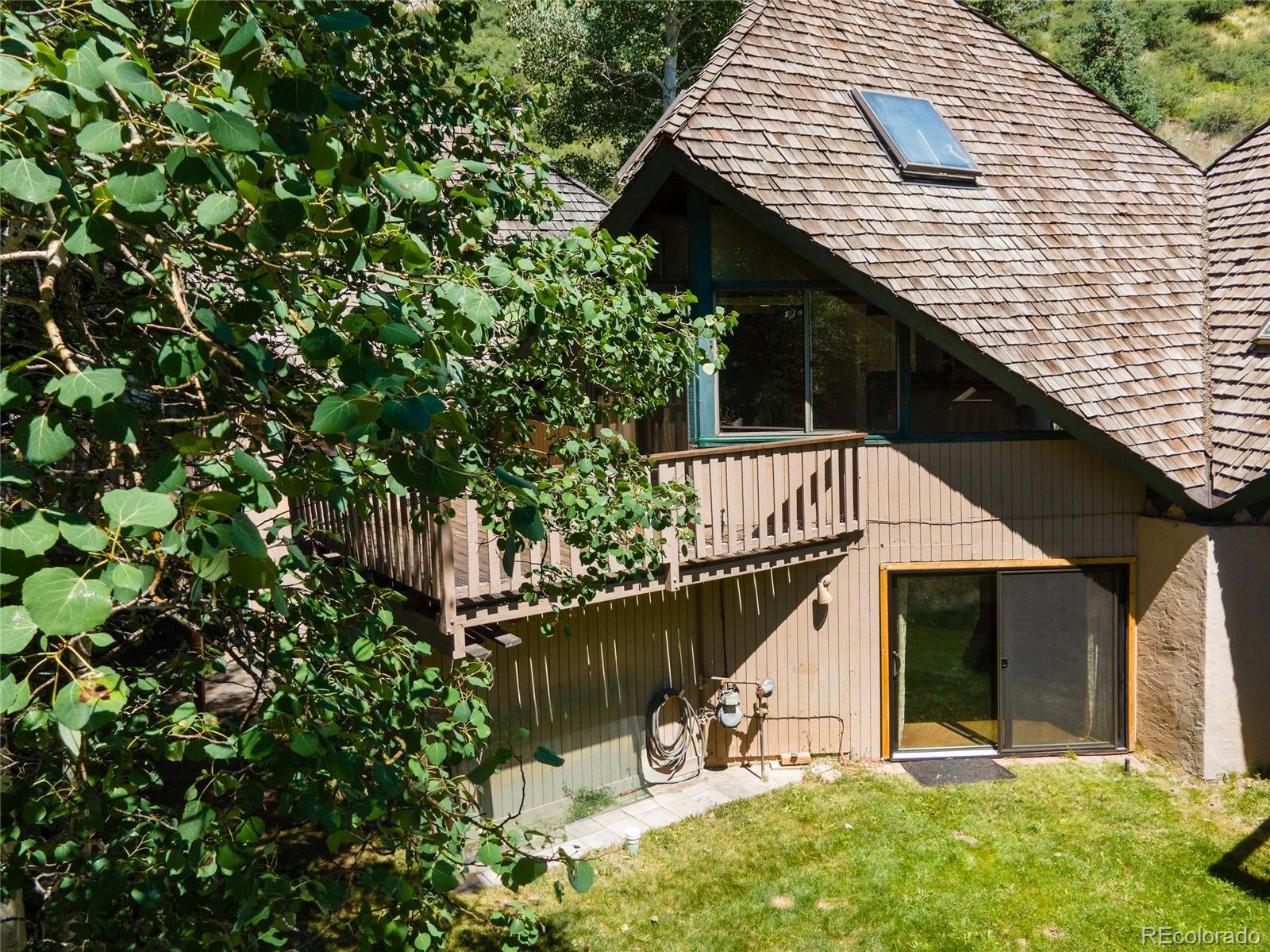 1400 Lions Ridge Loop, Unit A5 Vail, CO 81657 - Photo 28 of 28 a roof deck with table and chairs under an umbrella