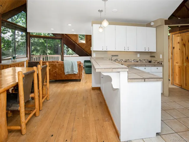 a kitchen with stainless steel appliances kitchen island wooden floors and view living room