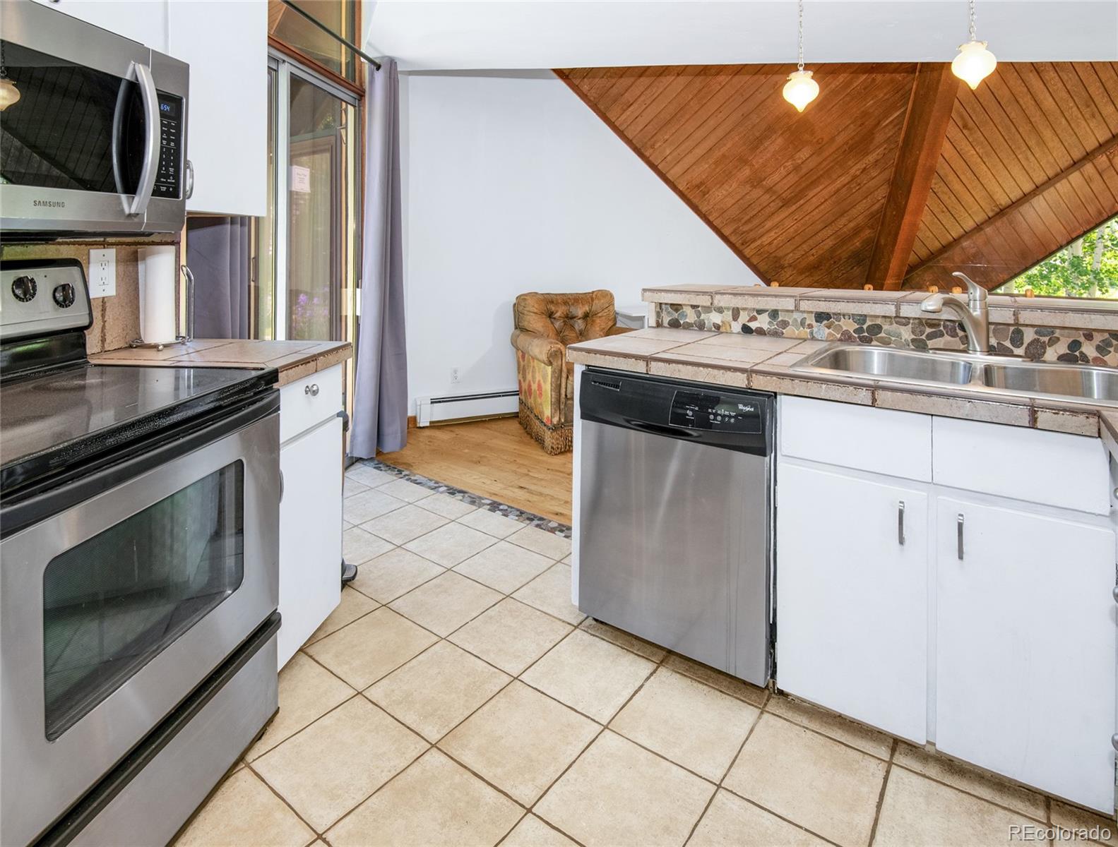 1400 Lions Ridge Loop, Unit A5 Vail, CO 81657 - Photo 10 of 28 a kitchen with stainless steel appliances granite countertop a stove a sink and a microwave