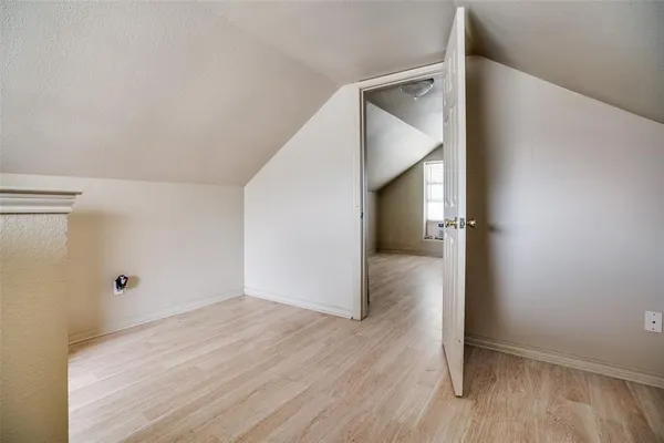 an empty room with wooden floor and entryway