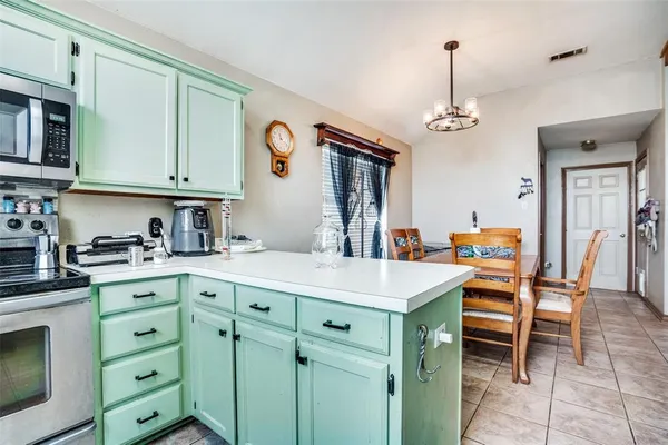 a kitchen with a table chairs and white cabinets