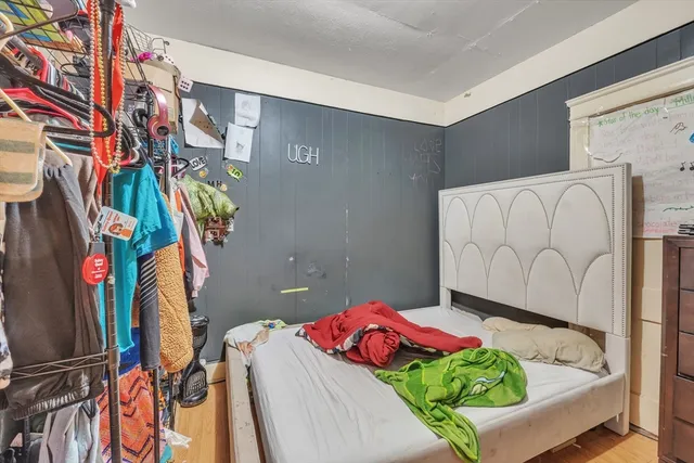 a bedroom with a bed and a painting on the wall