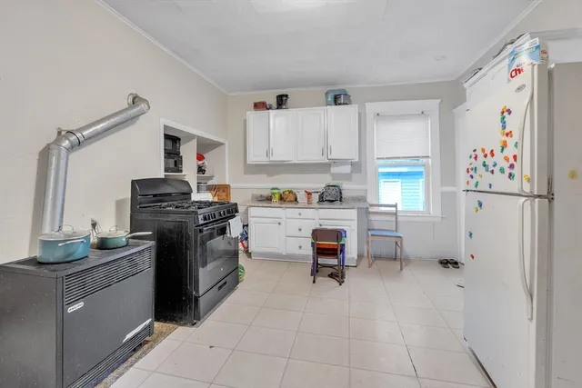 a kitchen with a refrigerator and white cabinets