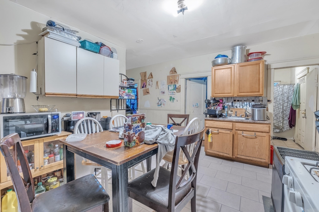 215 Beacon Street Worcester, MA 01610 - Photo 3 of 24 a kitchen with a dining table chairs sink and stove