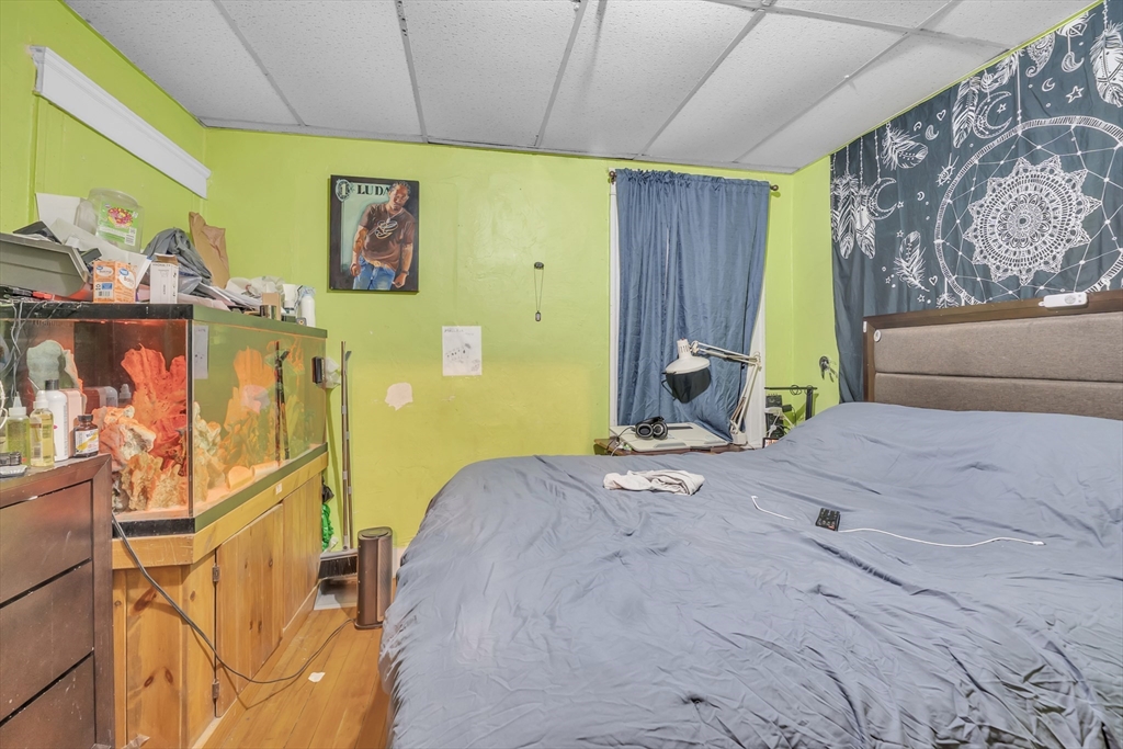 215 Beacon Street Worcester, MA 01610 - Photo 10 of 24 a bedroom with a bed and wooden floor