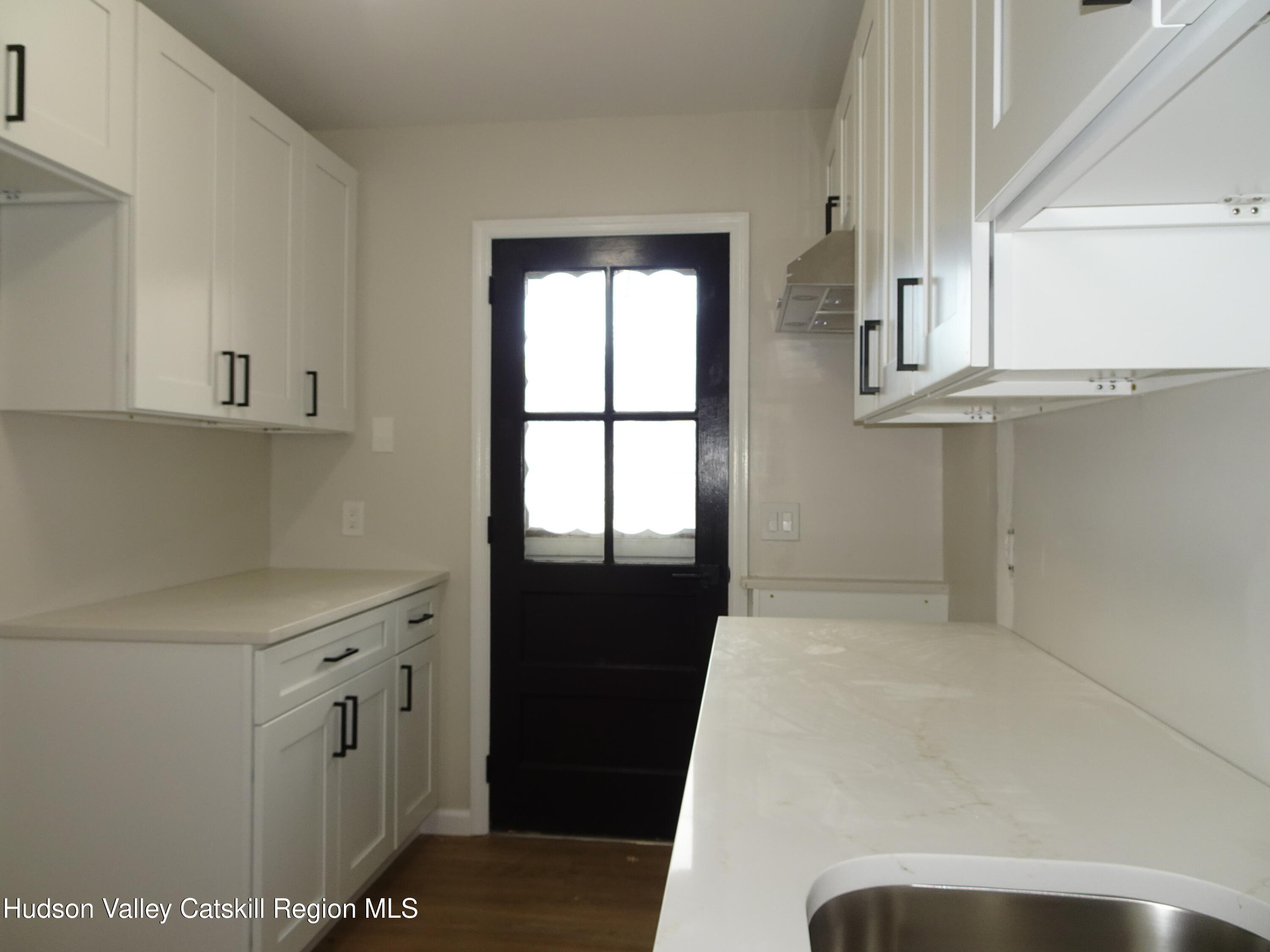 167 Highway 23, Unit 1C Claverack-Red Mills, NY 12513 - Photo 10 of 18 a view of a kitchen with white cabinets and a window