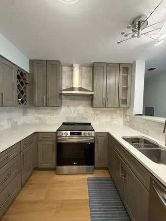 a kitchen with stainless steel appliances granite countertop a sink stove and cabinets