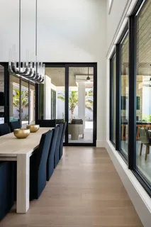 a kitchen with stainless steel appliances kitchen island granite countertop a table chairs in it and wooden floors