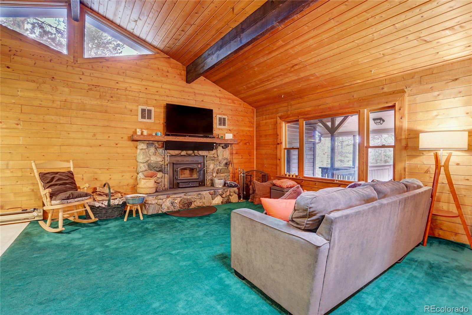 25 Granada Way Pine, CO 80470 - Photo 15 of 40 a living room with fireplace furniture and a flat screen tv