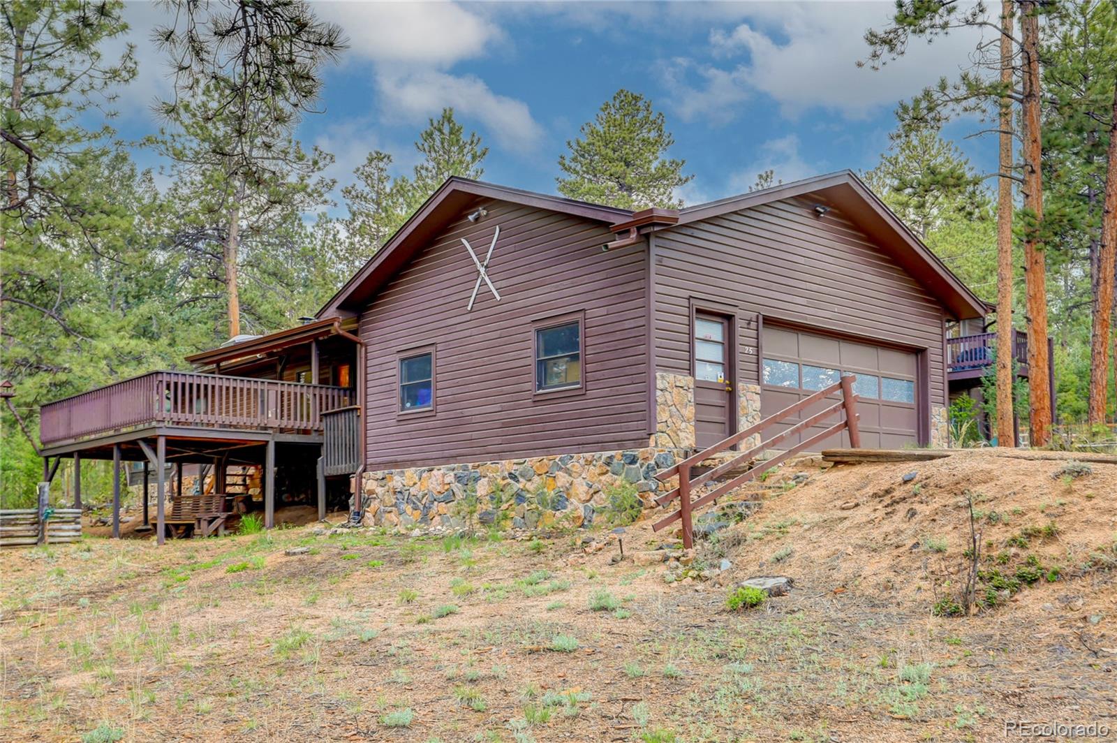 25 Granada Way Pine, CO 80470 - Photo 2 of 40 a front view of a house with a yard and garage