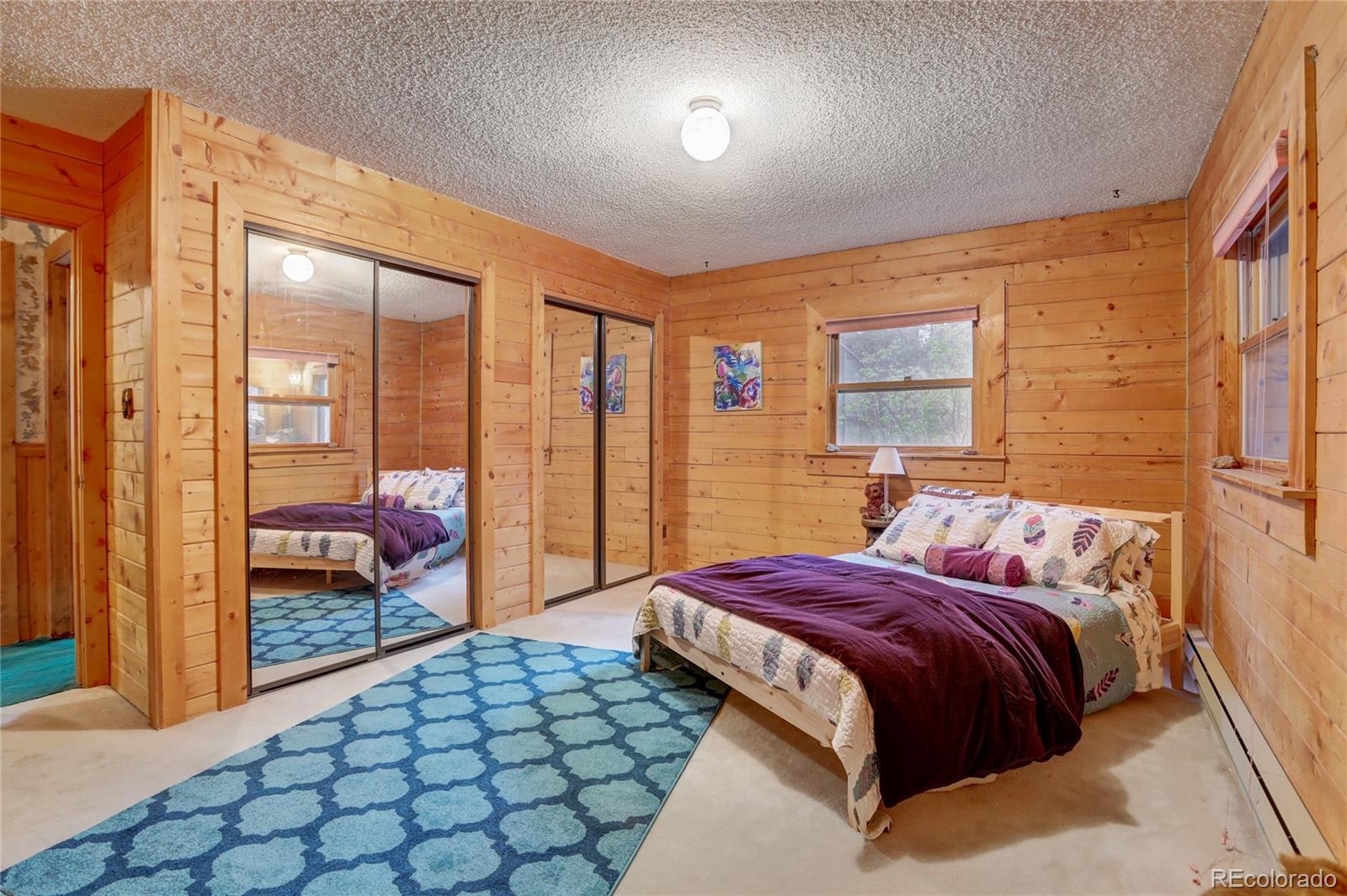 25 Granada Way Pine, CO 80470 - Photo 22 of 40 a bedroom with a large bed and a large window