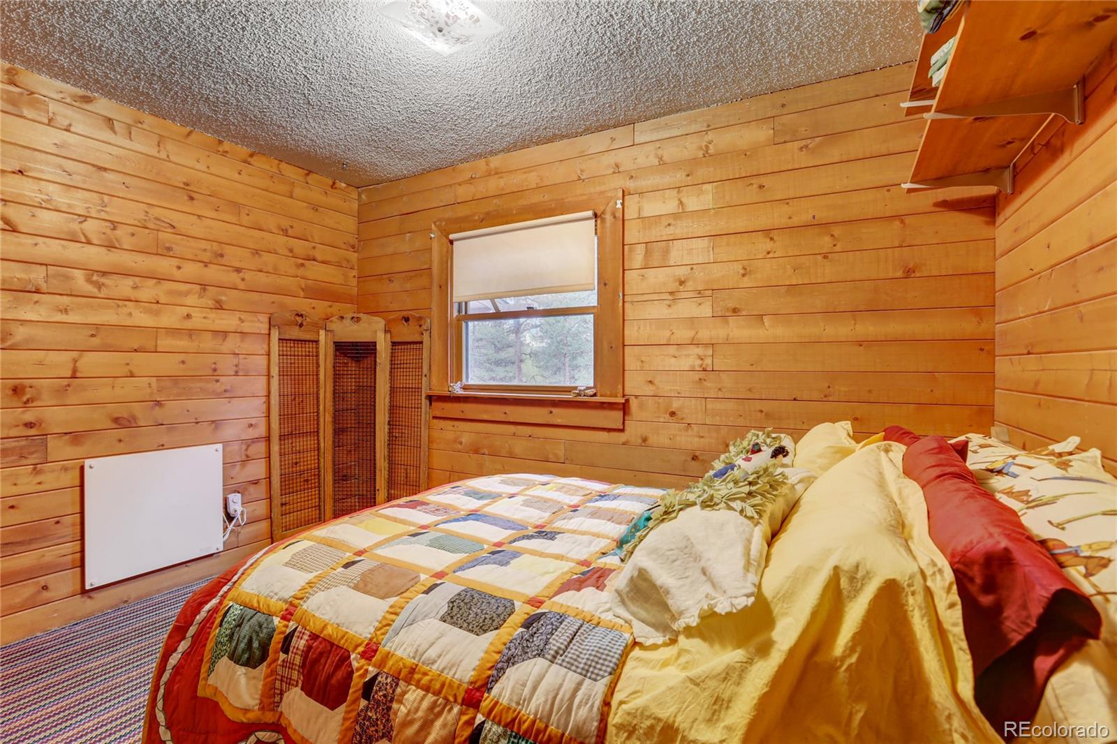 25 Granada Way Pine, CO 80470 - Photo 24 of 40 a bedroom with a bed and a wooden floor
