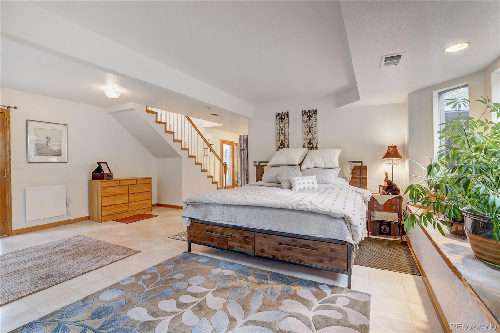 25 Granada Way Pine, CO 80470 - Photo 8 of 40 a spacious bedroom with a bed and a potted plant