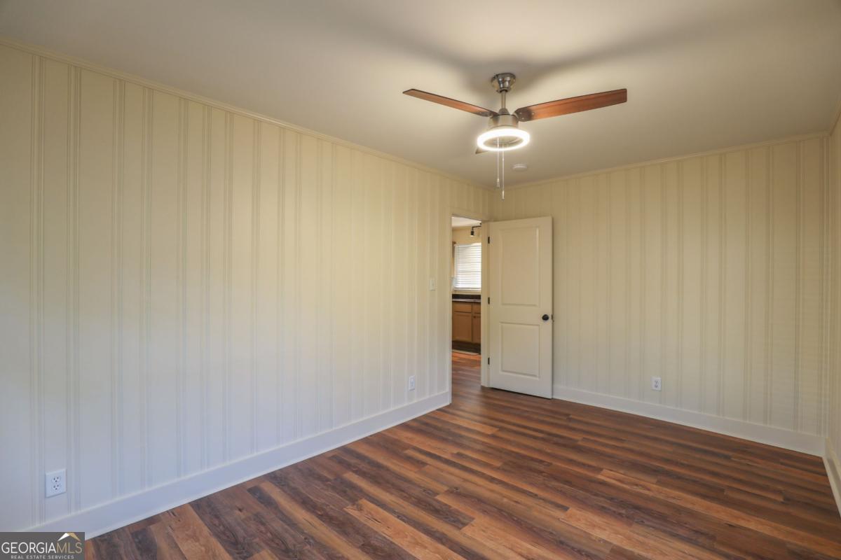 127 Fourth Street Southwest Milledgeville, GA 31061 - Photo 16 of 28 an empty room with wooden floor and a ceiling fan