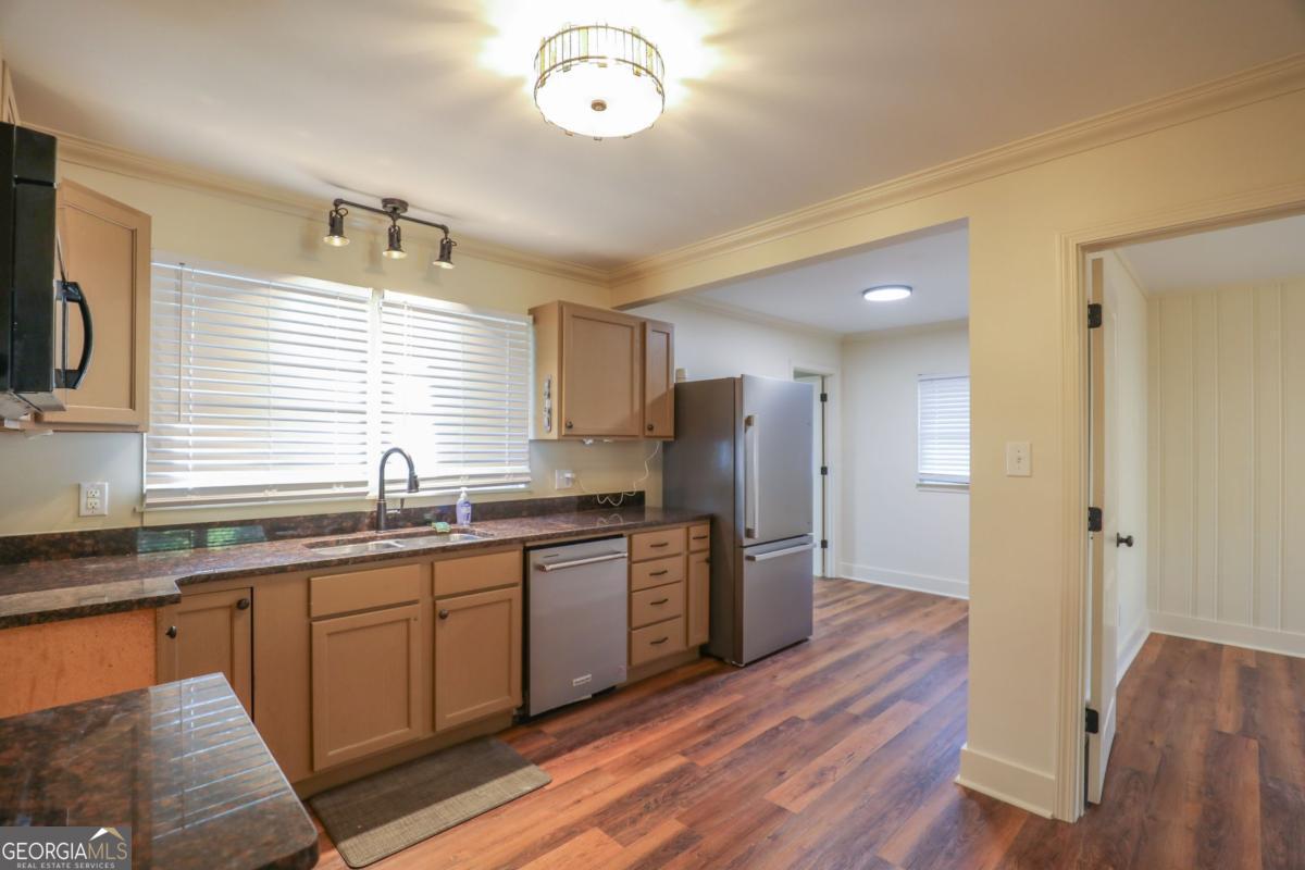 127 Fourth Street Southwest Milledgeville, GA 31061 - Photo 8 of 28 a kitchen with stainless steel appliances granite countertop a sink dishwasher a refrigerator and a stove with wooden floor