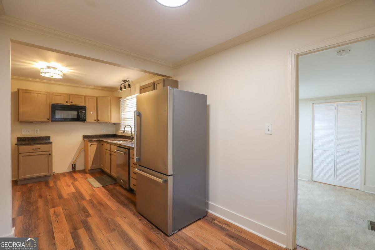 127 Fourth Street Southwest Milledgeville, GA 31061 - Photo 9 of 28 a kitchen with a refrigerator cabinets and wooden floor