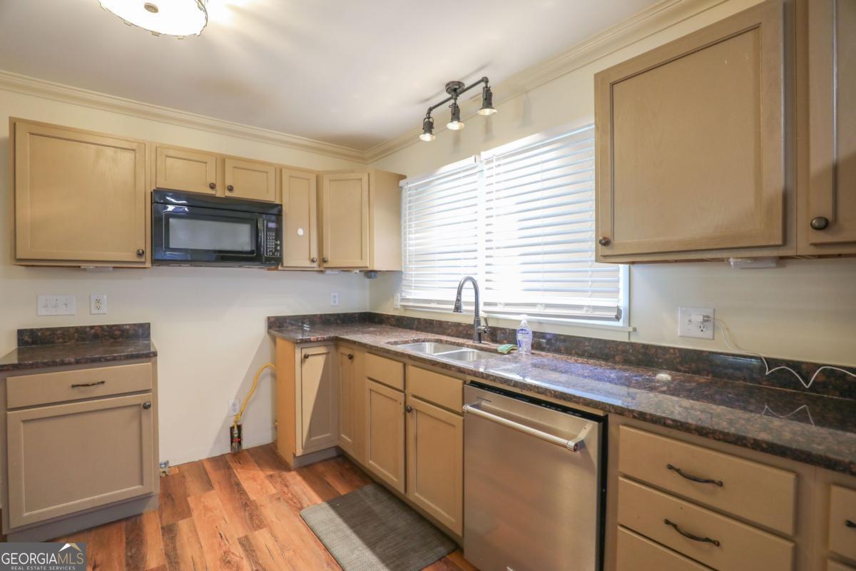 127 Fourth Street Southwest Milledgeville, GA 31061 - Photo 10 of 28 a kitchen with granite countertop cabinets stainless steel appliances a sink and wooden floor