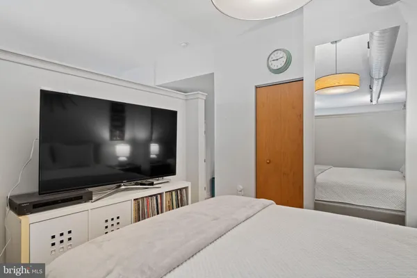 a bedroom with a bed and a flat screen tv