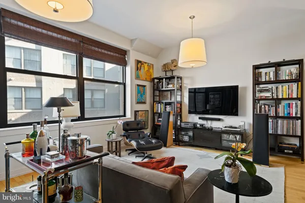 a work room with furniture a flat screen tv and a window