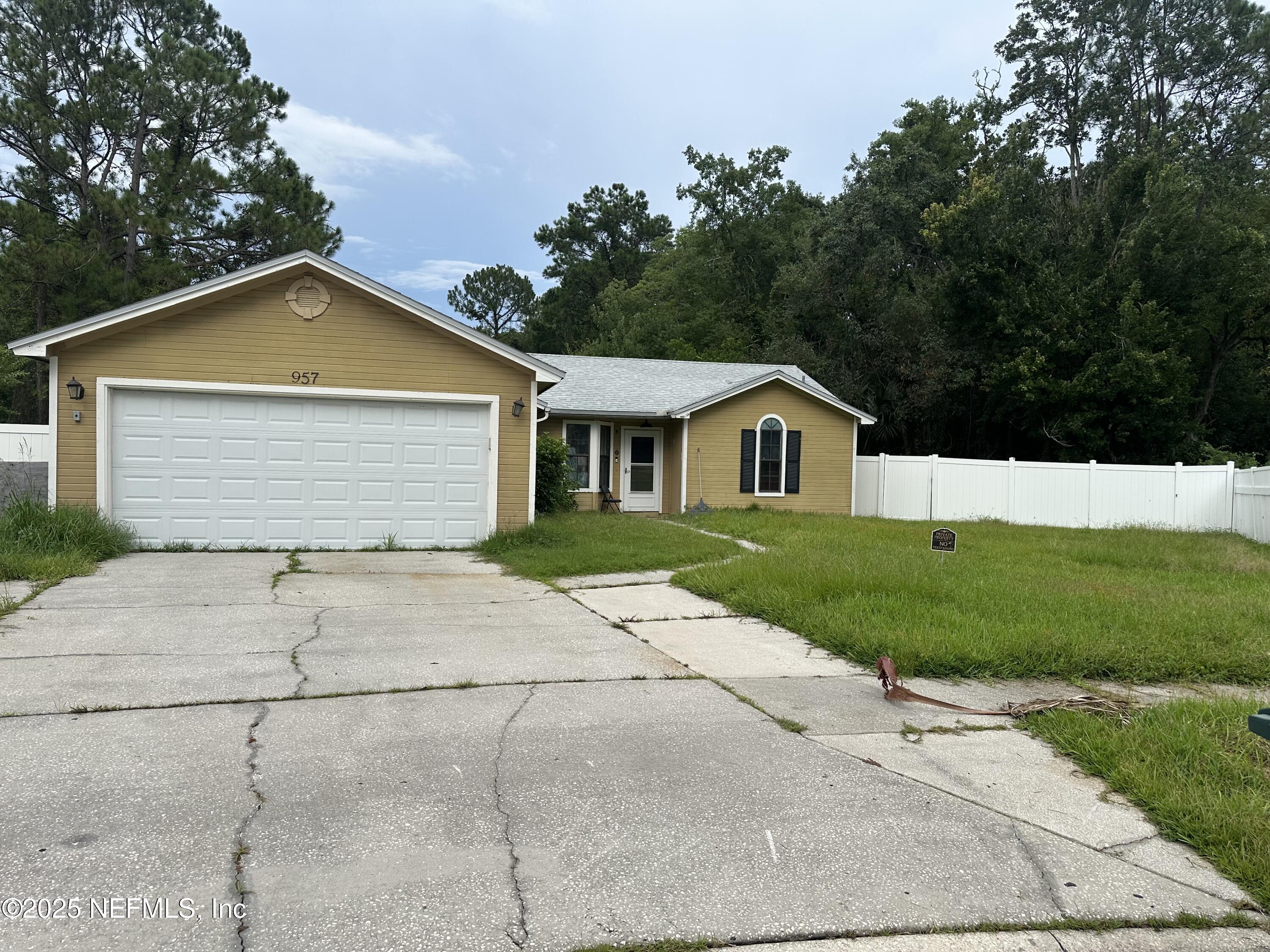 957 Aries Road West Jacksonville, FL 32216 - Photo 1 of 28 a front view of a house with a yard and garage