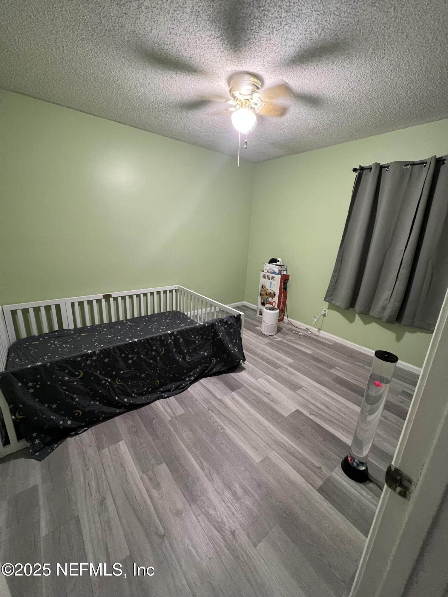 957 Aries Road West Jacksonville, FL 32216 - Photo 14 of 28 a bedroom with a bed and a chandelier