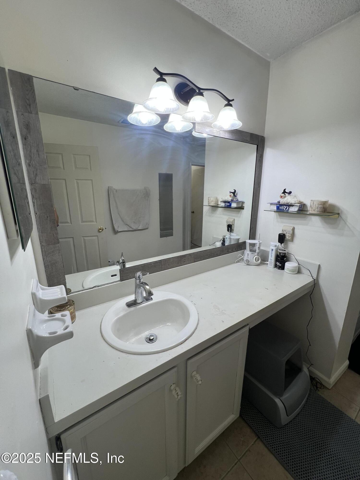 957 Aries Road West Jacksonville, FL 32216 - Photo 23 of 28 a bathroom with a sink and a mirror