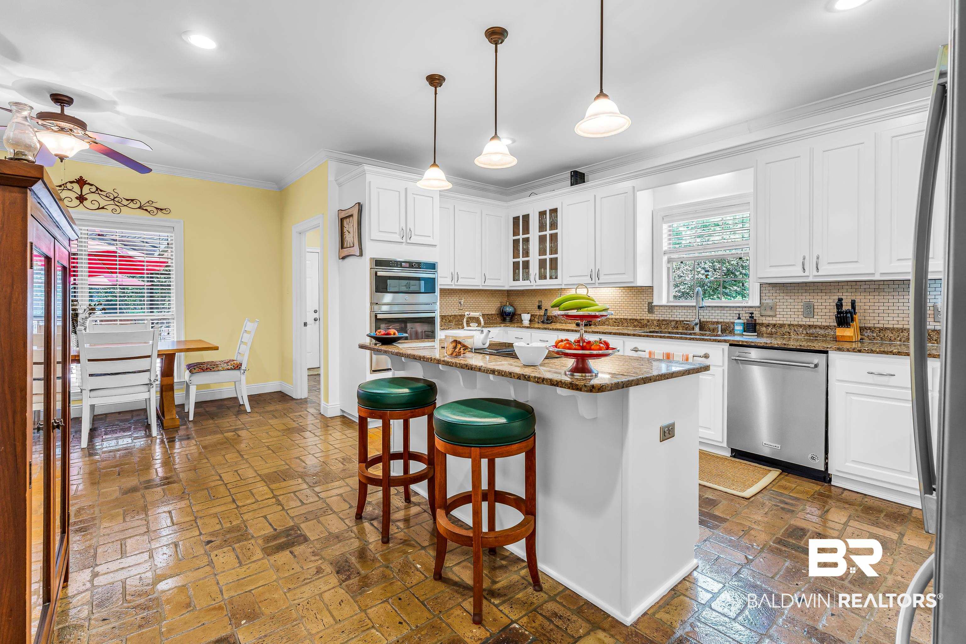 7014 Blakeley Road Daphne, AL 36527 - Photo 29 of 45 Kitchen featuring brick-patterned flooring, white cabinetry, granite countertops, and stainless steel appliances