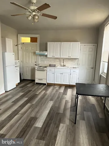 a kitchen with a wooden floor window and cabinets