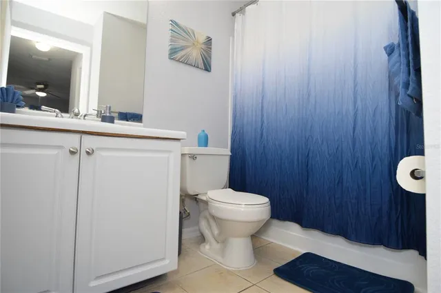 a view of a lake with a bench and trees in the background