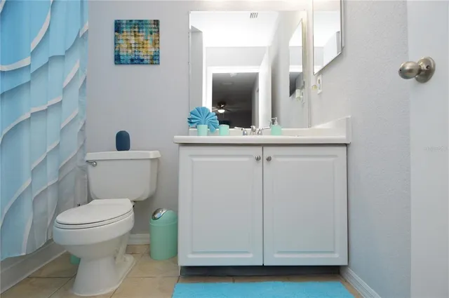 a view of swimming pool with seating space and trees in the background