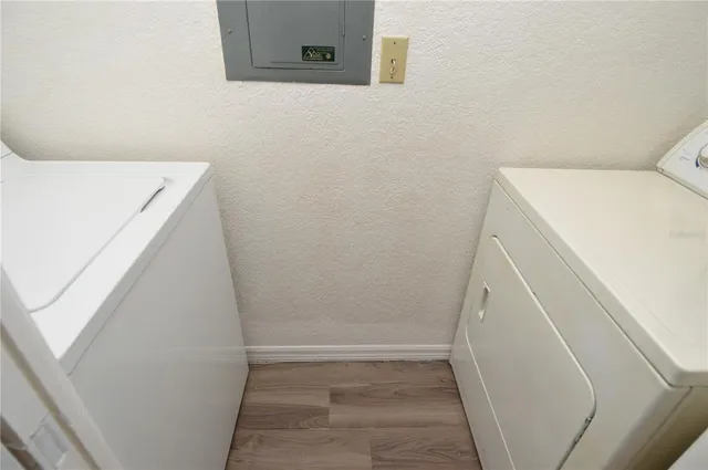 a living room with furniture a rug and a dining table with wooden floor