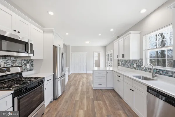 a kitchen with stainless steel appliances a stove sink and cabinets