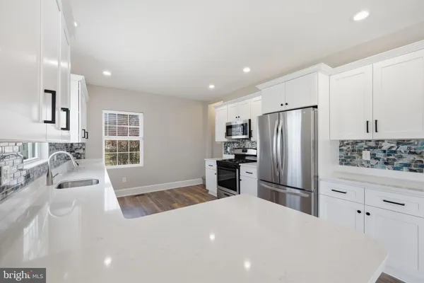 a kitchen with stainless steel appliances a refrigerator and a stove top oven