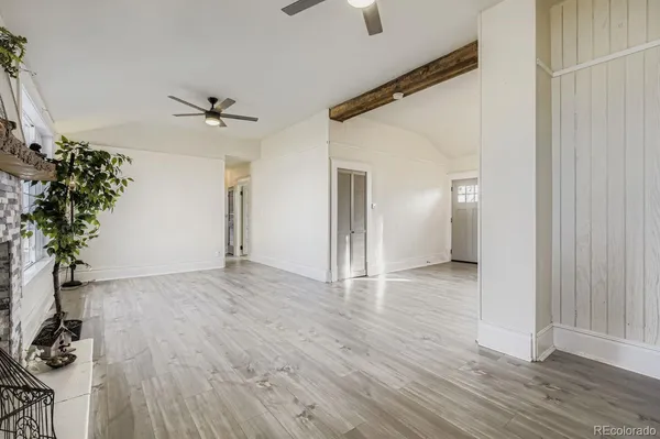 a walk in closet with wooden floor