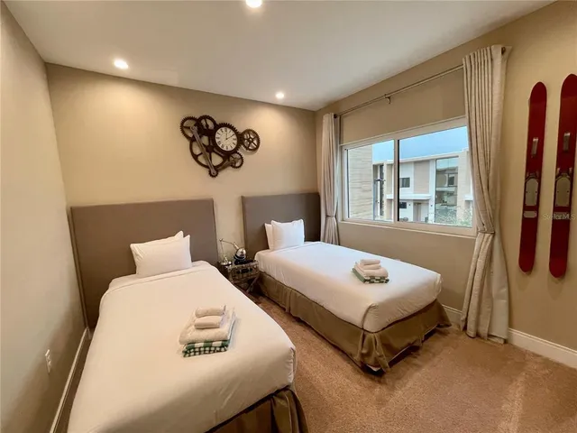 a bedroom with 2 bed and a window