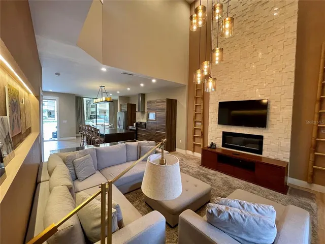 a living room with furniture a flat screen tv and kitchen view