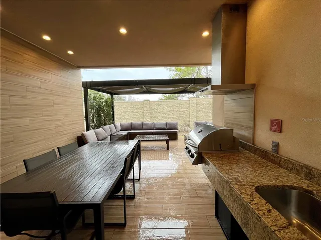 a kitchen with a table chairs stove and wooden floor