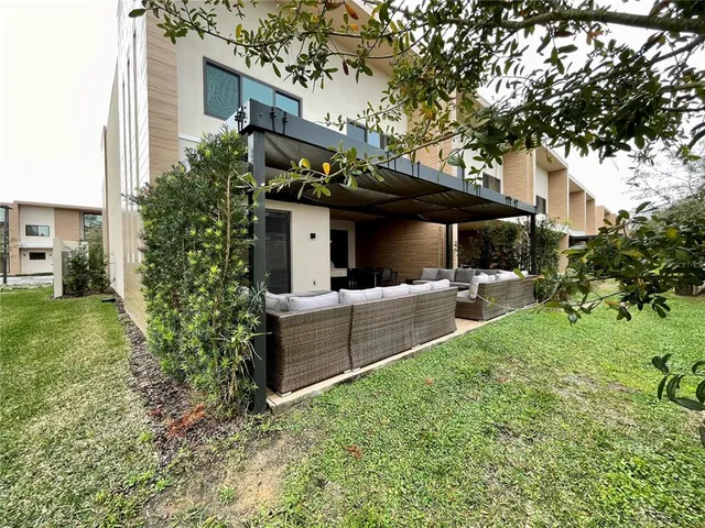 a view of house with backyard and furniture