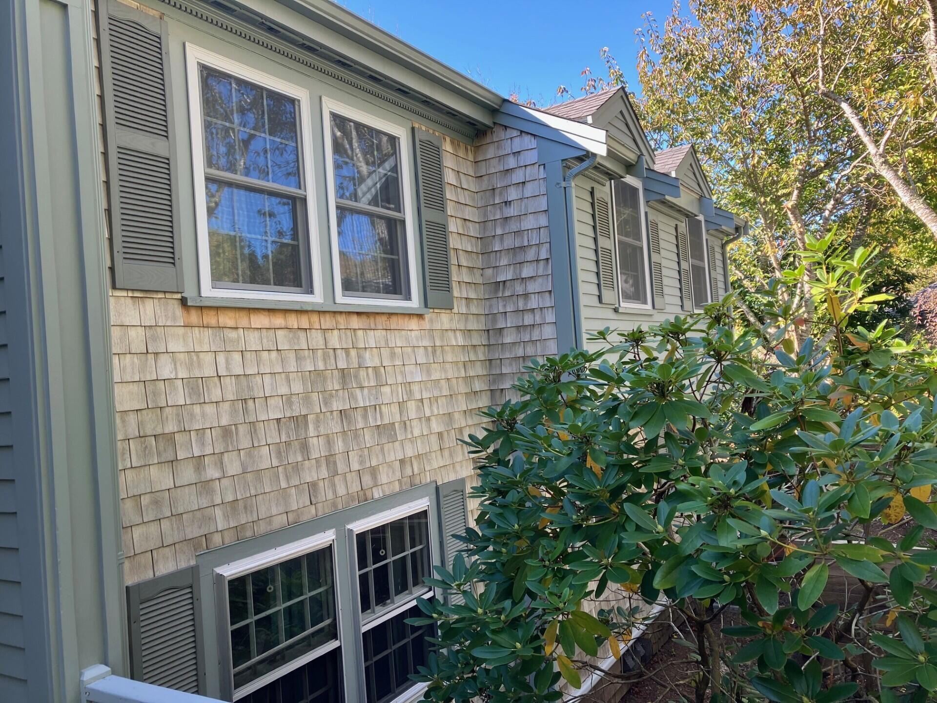 407 Orleans Road, Unit B Chatham, MA 02650 - Photo 3 of 16 a brick building with a window and potted plants