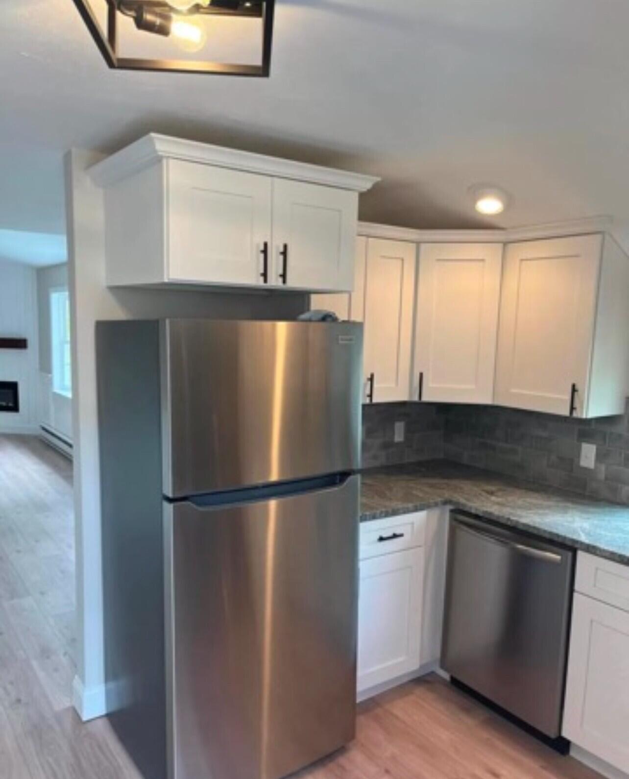 407 Orleans Road, Unit B Chatham, MA 02650 - Photo 9 of 16 a kitchen with stainless steel appliances granite countertop a refrigerator a sink and white cabinets
