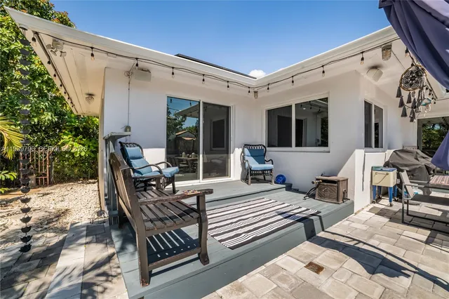 a view of a patio with table and chairs with wooden floor and fence
